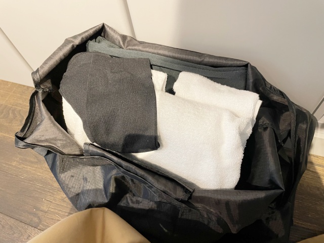惣湯テラスの利用受付後に手渡されるタオルと館内着が入ったバックを撮影した写真