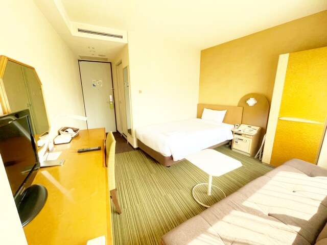 新横浜プリンスホテル・最安値シングルルームの窓側からベッドと入口を撮影した画像