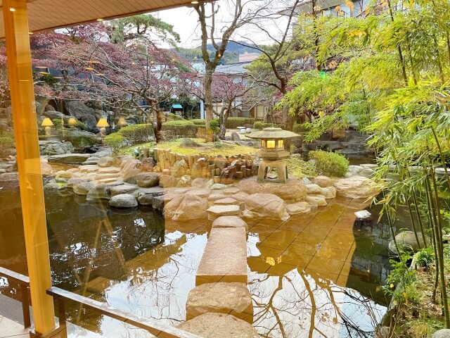 松川館ロビーのソファに腰掛けて庭園の植物と池を撮影した画像